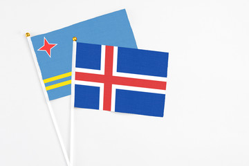 Obraz premium Iceland and Aruba stick flags on white background. High quality fabric, miniature national flag. Peaceful global concept.White floor for copy space.