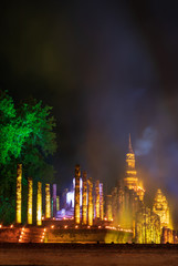 Old Buddhist temple at night with lights and smoke.