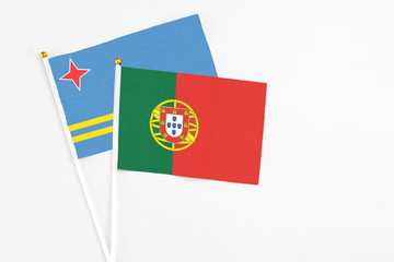 Portugal and Aruba stick flags on white background. High quality fabric, miniature national flag. Peaceful global concept.White floor for copy space.