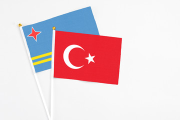 Turkey and Aruba stick flags on white background. High quality fabric, miniature national flag. Peaceful global concept.White floor for copy space.