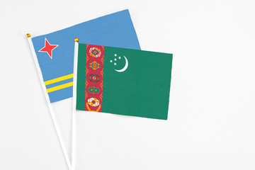 Turkmenistan and Aruba stick flags on white background. High quality fabric, miniature national flag. Peaceful global concept.White floor for copy space.
