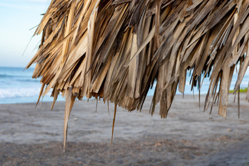 Straw roof, partial. Beach scenery. Thatched palapa. Straw sun roof. tropical and summer vacation...