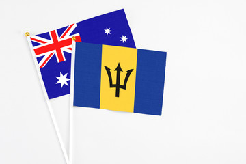 Barbados and Australia stick flags on white background. High quality fabric, miniature national flag. Peaceful global concept.White floor for copy space.