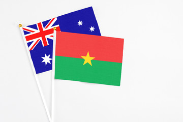 Burkina Faso and Australia stick flags on white background. High quality fabric, miniature national flag. Peaceful global concept.White floor for copy space.