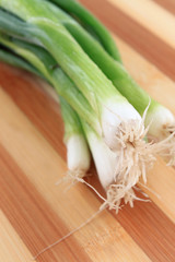 Green onions on a wooden cutting board