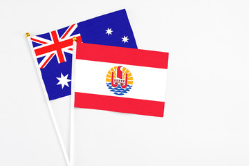 Fototapeta premium French Polynesia and Australia stick flags on white background. High quality fabric, miniature national flag. Peaceful global concept.White floor for copy space.
