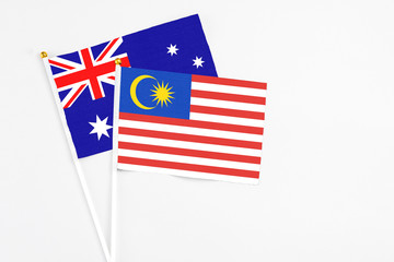 Malaysia and Australia stick flags on white background. High quality fabric, miniature national flag. Peaceful global concept.White floor for copy space.