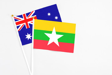 Fototapeta premium Myanmar and Australia stick flags on white background. High quality fabric, miniature national flag. Peaceful global concept.White floor for copy space.