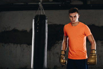 Angry muay thai fighter practicing punch on punching bag