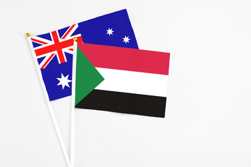 Sudan and Australia stick flags on white background. High quality fabric, miniature national flag. Peaceful global concept.White floor for copy space.