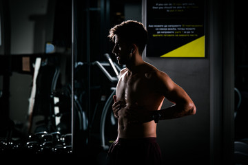 Obraz na płótnie Canvas Slim muscular man lifting weights in the gym