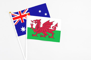 Wales and Australia stick flags on white background. High quality fabric, miniature national flag. Peaceful global concept.White floor for copy space.