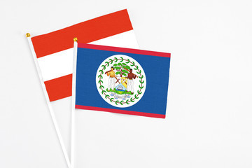 Belize and Austria stick flags on white background. High quality fabric, miniature national flag. Peaceful global concept.White floor for copy space.