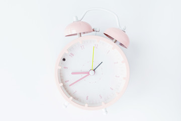 Vintage alarm clock pink color on white background. Rest hours time of life good. Flat lay, top view, copy space, mockup, overhead