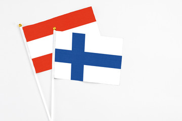 Finland and Austria stick flags on white background. High quality fabric, miniature national flag. Peaceful global concept.White floor for copy space.