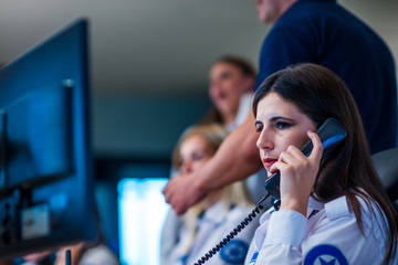 Security guards working in surveillance room. Female security guard with portable transmitter...
