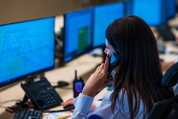 Security guards working in surveillance room. Female security guard with portable transmitter...