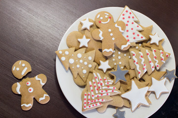 gingerbread cookies on a white plate on a dark brown wooden table