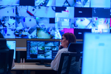 Team working on the System Control Room, Technical Operator Works at His Workstation with Multiple Displays, Security guards working on multiple monitors...