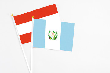 Guatemala and Austria stick flags on white background. High quality fabric, miniature national flag. Peaceful global concept.White floor for copy space.