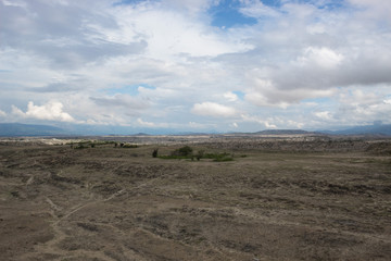 Los Hoyos sand roads with forest, dunes, clouds and blue sky at Tatacoa Desert, Huila, Colombia. 