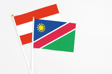 Namibia and Austria stick flags on white background. High quality fabric, miniature national flag. Peaceful global concept.White floor for copy space.