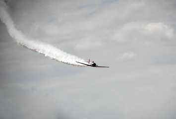A demonstrating airplane and a cloud of smoke behind it