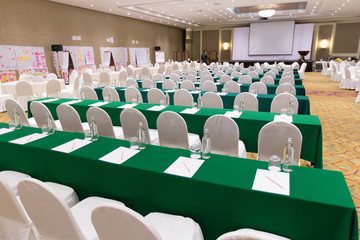 Paper, pencil, water bottle, glass on the table in the seminar room background