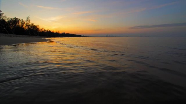Peaceful Landscape of Calm Sea Waves on Sandy Beach after Sunset