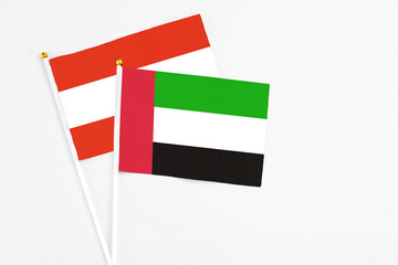 United Arab Emirates and Austria stick flags on white background. High quality fabric, miniature national flag. Peaceful global concept.White floor for copy space.