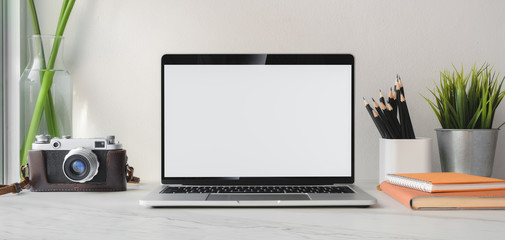 Obraz premium Cropped shot of modern office room with blank screen laptop computer