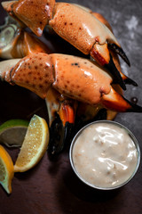 Fresh Stone Crab Claws with lemon and lime, sauce and ice in a dish in a restaurant