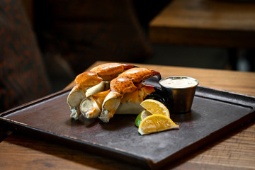 Fresh Stone Crab Claws with lemon and lime, sauce in a dish in a restaurant