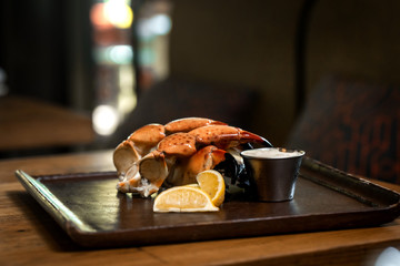 Fresh Stone Crab Claws with lemon and lime, sauce in a dish in a restaurant