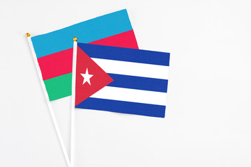 Cuba and Azerbaijan stick flags on white background. High quality fabric, miniature national flag. Peaceful global concept.White floor for copy space.