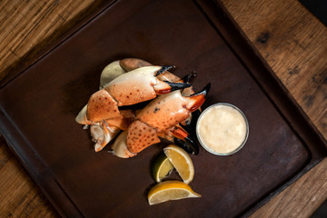 Fresh Stone Crab Claws with lemon and lime, sauce in a dish in a restaurant