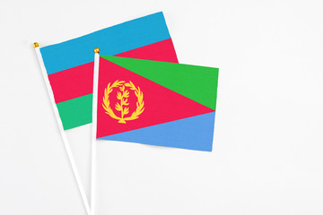 Eritrea and Azerbaijan stick flags on white background. High quality fabric, miniature national flag. Peaceful global concept.White floor for copy space.