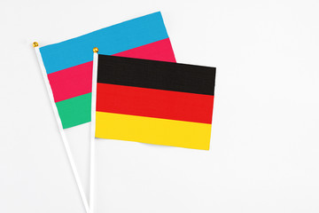 Germany and Azerbaijan stick flags on white background. High quality fabric, miniature national flag. Peaceful global concept.White floor for copy space.