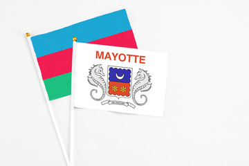 Mayotte and Azerbaijan stick flags on white background. High quality fabric, miniature national flag. Peaceful global concept.White floor for copy space.