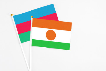 Niger and Azerbaijan stick flags on white background. High quality fabric, miniature national flag. Peaceful global concept.White floor for copy space.