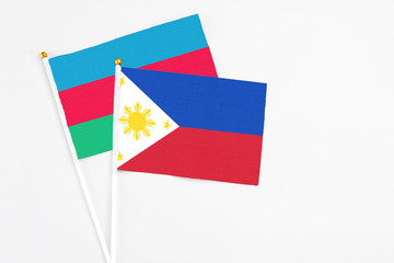 Philippines and Azerbaijan stick flags on white background. High quality fabric, miniature national flag. Peaceful global concept.White floor for copy space.