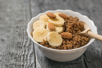 Wooden spoon in a Cup of quinoa porridge.