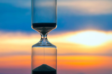 Hourglass on the background of a sunset. The value of time in life. An eternity..
