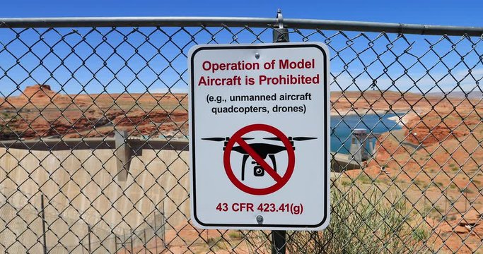 Glen Canyon Dam Page Arizona warning sign no drone flying. U.S. Route 89 across the Colorado River. Reservoir is called Lake Powell. Industrial power plant. Utah Arizona desert.