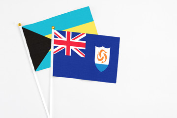 Fototapeta premium Anguilla and Bahamas stick flags on white background. High quality fabric, miniature national flag. Peaceful global concept.White floor for copy space.