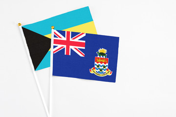 Cayman Islands and Bahamas stick flags on white background. High quality fabric, miniature national flag. Peaceful global concept.White floor for copy space.