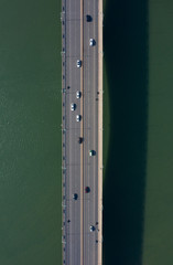 Fototapeta premium Car driving on the bridge across the river top view
