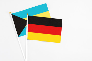 Germany and Bahamas stick flags on white background. High quality fabric, miniature national flag. Peaceful global concept.White floor for copy space.