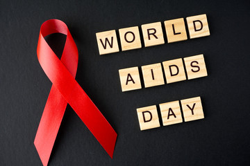 Red ribbon on a black background. World Aids Day concept