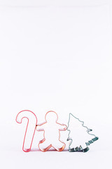 Multicolor cookie cutters on white sparkling background with bokeh lights. Holiday Christmas and New Year background. Vertical